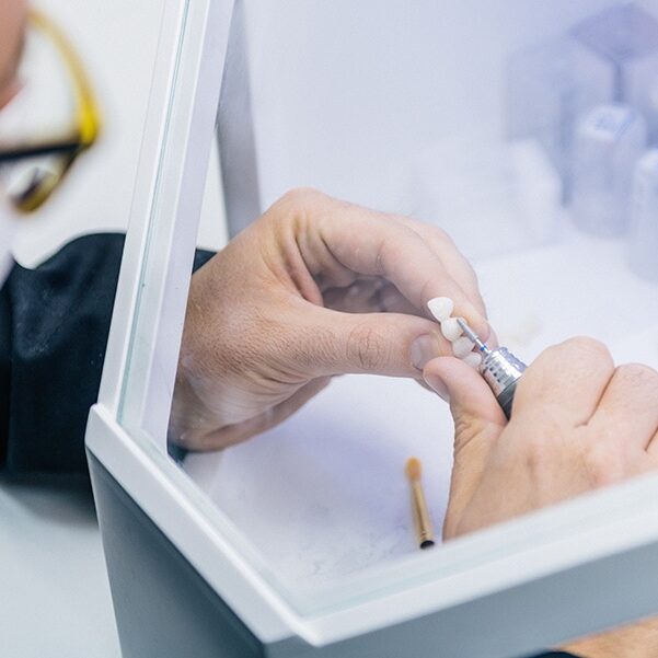 Dental technician or dentist working with tooth dentures in his laboratory